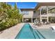 Gorgeous backyard featuring a modern pool, spa, outdoor seating, and mature tropical landscaping at 7508 N Ola Ave, Tampa, FL 33604