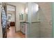 Elegant bathroom featuring a walk-in shower, granite countertops, and a view into the bedroom at 7508 N Ola Ave, Tampa, FL 33604