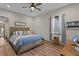 Cozy bedroom featuring hardwood floors, neutral walls, a ceiling fan, and plenty of natural light at 7508 N Ola Ave, Tampa, FL 33604