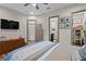 Bedroom with hardwood floors, ensuite bathroom, walk-in closet, and built-in shelving at 7508 N Ola Ave, Tampa, FL 33604