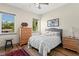 Cozy bedroom with natural light, wood floors, a ceiling fan, and two large windows framing lush greenery at 7508 N Ola Ave, Tampa, FL 33604