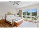 Bright bedroom with large windows, wood floors, and views of the lush gardens outside at 7508 N Ola Ave, Tampa, FL 33604