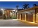Inviting home exterior showcasing a three-car garage, landscaped entryway, and charming stone accents at twilight at 7508 N Ola Ave, Tampa, FL 33604