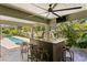Charming outdoor bar with seating, surrounded by lush greenery and a refreshing pool at 7508 N Ola Ave, Tampa, FL 33604
