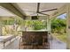 Inviting outdoor bar area with seating, offering views of the lush landscaping and pool at 7508 N Ola Ave, Tampa, FL 33604
