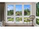 Bedroom view with three large windows offering panoramic garden scenery and a glimpse of the pool at 7508 N Ola Ave, Tampa, FL 33604