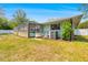The backyard features a pool enclosure, outdoor A/C, and well-maintained grass at 7660 Holiday Dr, Spring Hill, FL 34606