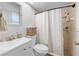 Bright bathroom featuring a vanity with modern sink and tiled shower with patterned shower curtain at 7660 Holiday Dr, Spring Hill, FL 34606