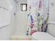 A bathroom features white marble floors and shower with a floral shower curtain at 7660 Holiday Dr, Spring Hill, FL 34606