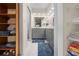 A bathroom features a double vanity with gray cabinets and marble floors with a view into a closet at 7660 Holiday Dr, Spring Hill, FL 34606