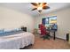 A bedroom has a ceiling fan, closet, and a computer desk with monitor and gaming chair at 7660 Holiday Dr, Spring Hill, FL 34606