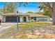 Charming single-story home with a well-manicured lawn, screened garage and inviting arched entrance at 7660 Holiday Dr, Spring Hill, FL 34606