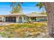 Inviting single-story home with a screened garage, lush front yard and charming arched entryway at 7660 Holiday Dr, Spring Hill, FL 34606