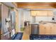 Well lit kitchen featuring stainless steel appliances, light wood cabinets, and marble countertops, complete with a modern refrigerator at 7660 Holiday Dr, Spring Hill, FL 34606