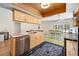 Bright kitchen featuring light wood cabinets, stainless steel appliances, and a marble countertop island with open sight lines at 7660 Holiday Dr, Spring Hill, FL 34606