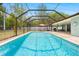 In-ground pool inside large screened in enclosure for year round enjoyment at 7660 Holiday Dr, Spring Hill, FL 34606