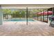 An enclosed pool is surrounded by brick pavers with a grill and outdoor furniture visible at 7660 Holiday Dr, Spring Hill, FL 34606