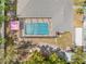 Aerial view of a screened-in pool, lush trees, and neighboring properties at 7660 Holiday Dr, Spring Hill, FL 34606