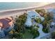 Breathtaking aerial view of a beachfront estate with lush landscaping and a circular driveway at 770 N Manasota Key Rd, Englewood, FL 34223