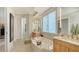 Soaking tub with dual vanities, bright mirror installation, and a linen closet door at 770 N Manasota Key Rd, Englewood, FL 34223
