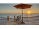 Secluded beach setup features a wooden walkway, chairs, and umbrella, offering an intimate waterfront experience at 770 N Manasota Key Rd, Englewood, FL 34223