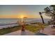 Picturesque beachside with sunset views from the patio with well-manicured lawn and potted flowers at 770 N Manasota Key Rd, Englewood, FL 34223
