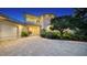 Luxurious two-story home at twilight showcases a grand entrance, a driveway, and mature landscaping at 770 N Manasota Key Rd, Englewood, FL 34223