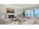 Bright living room with fireplace, waterfront views, and sliding doors to a deck at 770 N Manasota Key Rd, Englewood, FL 34223