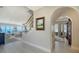 Open-concept living area with staircase, complemented by an archway and painting, offering bright and airy atmosphere at 770 N Manasota Key Rd, Englewood, FL 34223