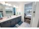 Beautiful bathroom featuring a double vanity with gray cabinets and a marble-tiled shower at 9263 Barrier Coast Trl, Parrish, FL 34219