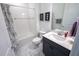 Bathroom featuring a tub-shower combo with white tile, gray vanity and framed art at 9263 Barrier Coast Trl, Parrish, FL 34219