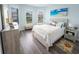 Bright bedroom with wood floors, a queen-sized bed, and large windows with natural light at 9263 Barrier Coast Trl, Parrish, FL 34219