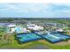 Aerial view of the community pool and recreational center with tennis courts and lovely landscaping at 9263 Barrier Coast Trl, Parrish, FL 34219
