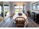 Sunlit dining room featuring an elegant light fixture and sliding glass doors to a screened-in patio with a water view at 9263 Barrier Coast Trl, Parrish, FL 34219