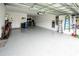Spacious garage featuring epoxy flooring, overhead storage, and ample room for multiple vehicles or a workshop at 9263 Barrier Coast Trl, Parrish, FL 34219