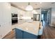Modern kitchen featuring a spacious island with seating, stainless steel appliances, and sleek countertops at 9263 Barrier Coast Trl, Parrish, FL 34219