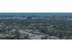 A wide aerial view of homes and businesses surrounded by lush greenery, with a waterfront in the distance at 10562 Lake Dr, Seminole, FL 33772