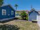 Backyard featuring a lawn, shed, and lush tropical plants at 10562 Lake Dr, Seminole, FL 33772
