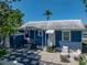 Back exterior of home featuring stone paver walkway, outdoor seating and covered entry at 10562 Lake Dr, Seminole, FL 33772