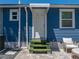 Exterior door featuring artificial grass stairs and an outdoor seating area at 10562 Lake Dr, Seminole, FL 33772
