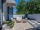 Back patio with stone pavers, outdoor seating and steps covered with synthetic turf at 10562 Lake Dr, Seminole, FL 33772