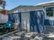 Exterior view of backyard shed with painted blue walls and white trim, set among stone pavers at 10562 Lake Dr, Seminole, FL 33772