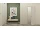 Hallway features a decorative bench, striking artwork, two doors, and neutral decor, creating an inviting transition space at 10824 Keato Beach Ct, Tampa, FL 33647