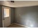 Bedroom with tile floors, neutral walls, a window, and a back door at 1106 Woodlawn Ave, Plant City, FL 33563