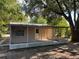 Back exterior view of house with tan siding and screened-in porch at 1106 Woodlawn Ave, Plant City, FL 33563
