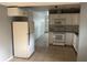 Spacious Kitchen showing white cabinets, range, refrigerator, and adjacent hallway at 1106 Woodlawn Ave, Plant City, FL 33563