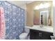 Bathroom featuring a sink with dark wood cabinets, toilet, shower with a decorative blue and white curtain at 11210 Wheeling Dr, Tampa, FL 33625