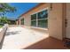 Beige home featuring a patio outside with some windows along the exterior, offering natural light at 11210 Wheeling Dr, Tampa, FL 33625