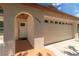 View of a beige one-story home's front entry, with a door leading to a two-car garage at 11210 Wheeling Dr, Tampa, FL 33625