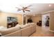 Spacious living room with a large sectional, a ceiling fan, and a TV with natural light at 11210 Wheeling Dr, Tampa, FL 33625
